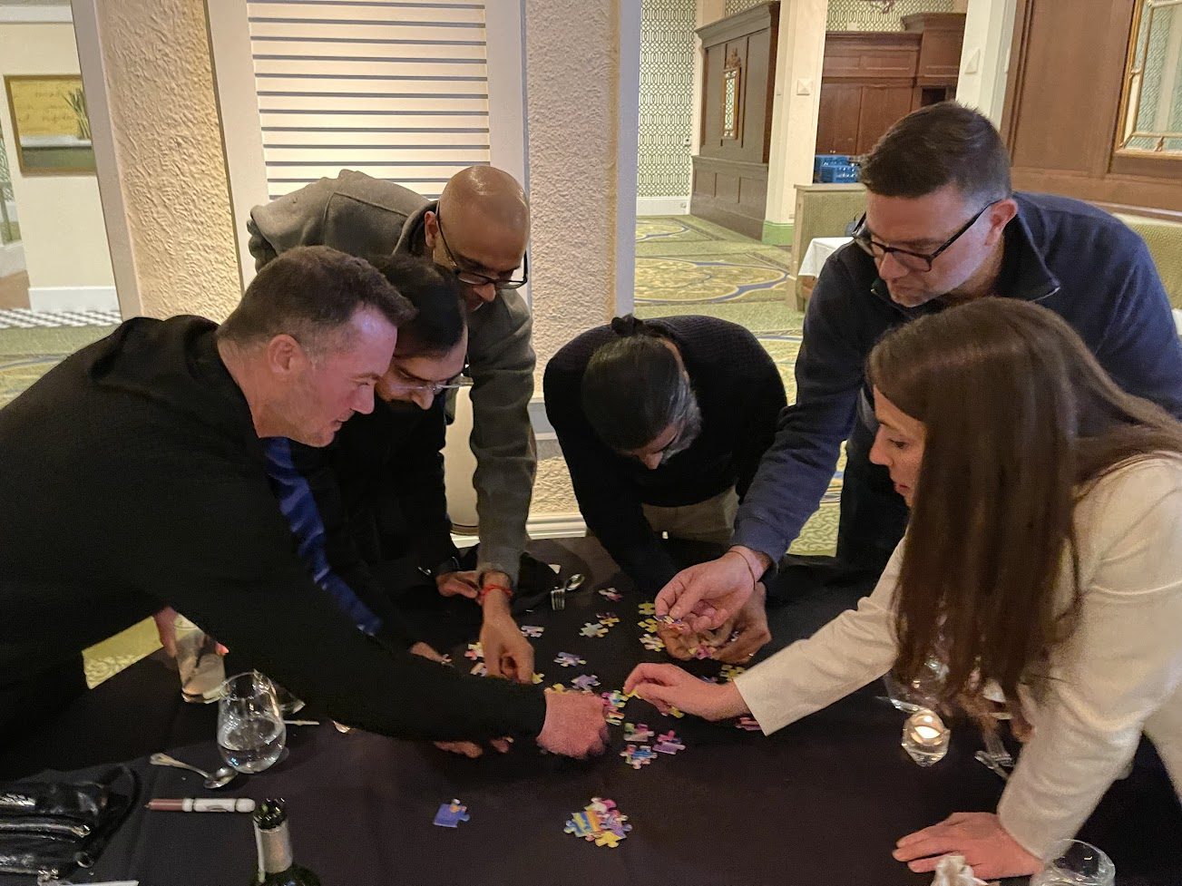 A group collaborating over a tabletop puzzle