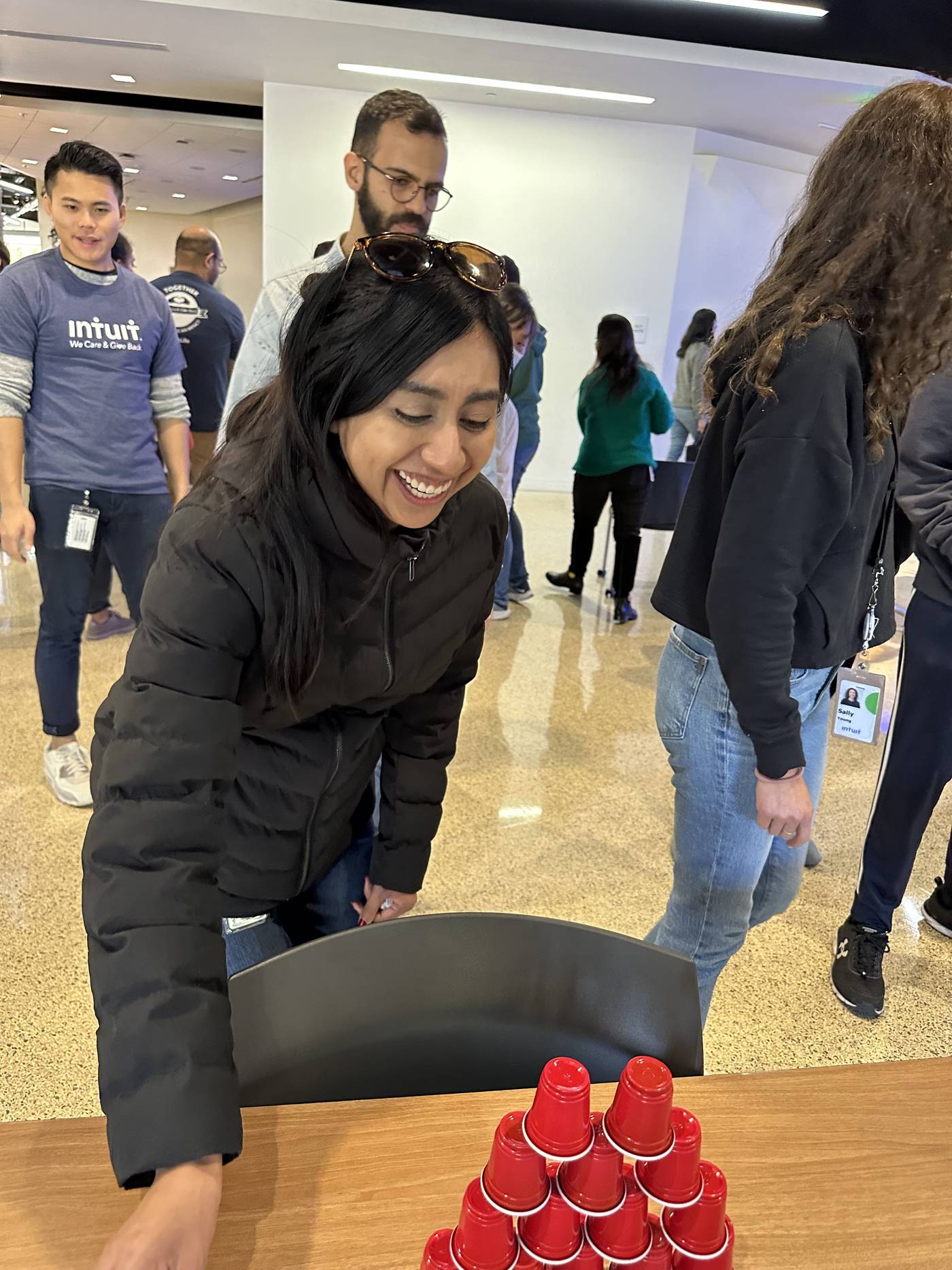 A participant smiling while stacking red cups